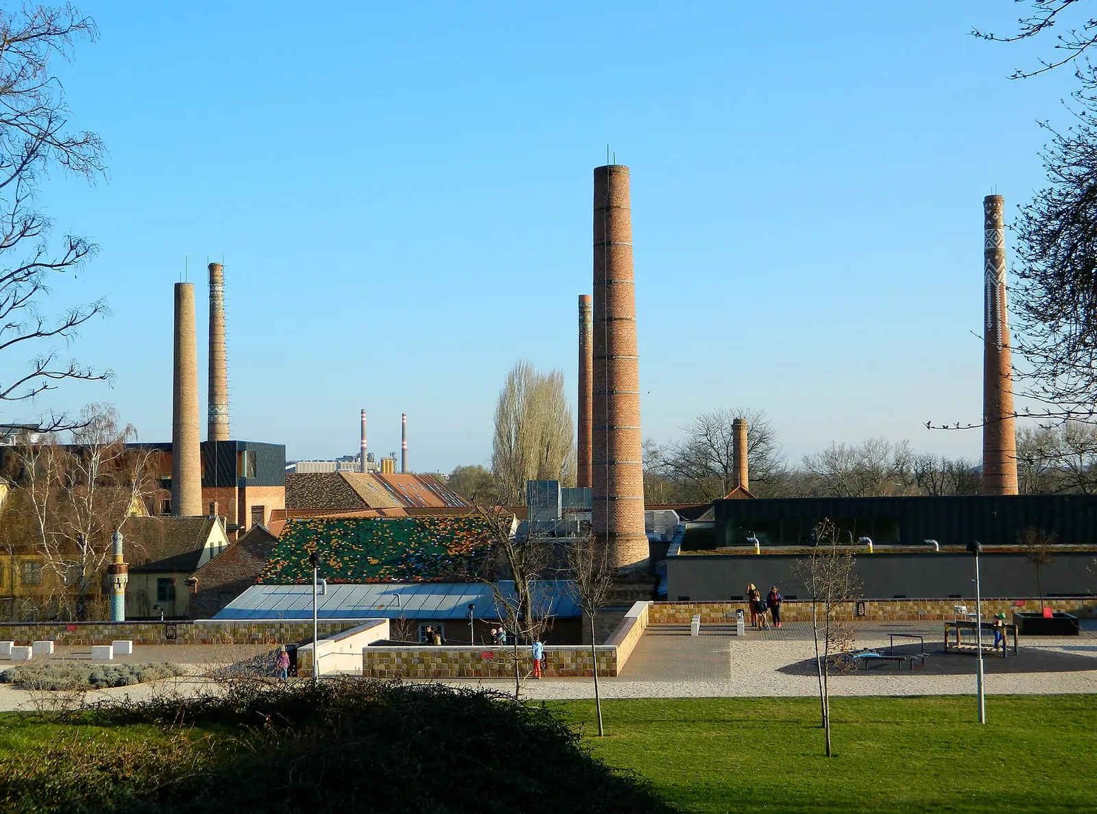 A Zsolnay Negyed gyárkéményei és a park